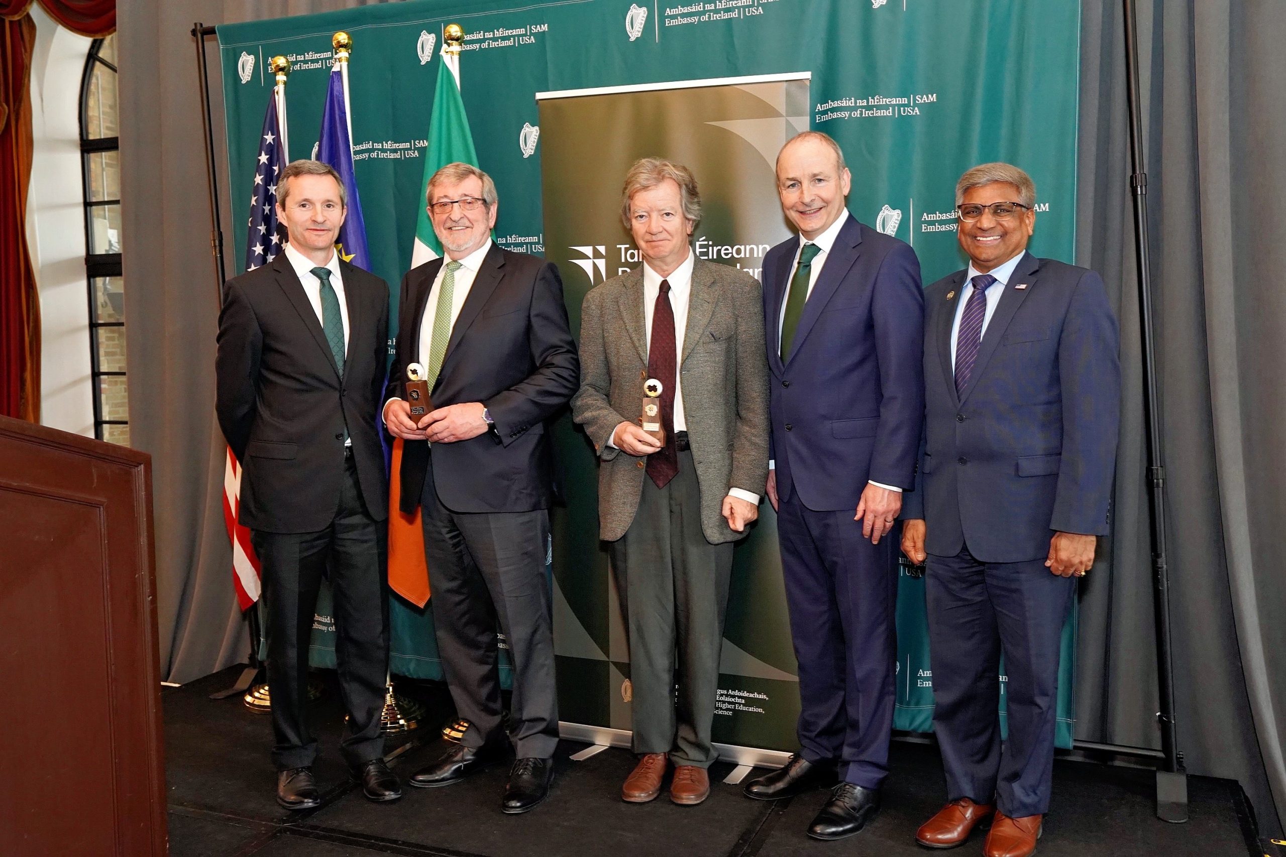 A picture from the Research Ireland St. Patrick’s Day Medal event in Washington D.C., featuring, named from left to right; Deputy CEO of Research Ireland, Dr Ciarán Seoighe, President and CEO of Northwell Health, Mr Michael Dowling (Industry Medal Recipient), Charles B Seelig Professor in Philosophy at Boston College, Prof Richard Kearney (Academic Medal recipient), Taoiseach Micheál Martin TD and Dr Sethuraman ‘Panch’ Panchanathan, Director of the National Science Foundation.|An image that reads "Research Ireland St. Patrick's Day Medal Winners 2025" beside an image of the St. Patrick's Day medals