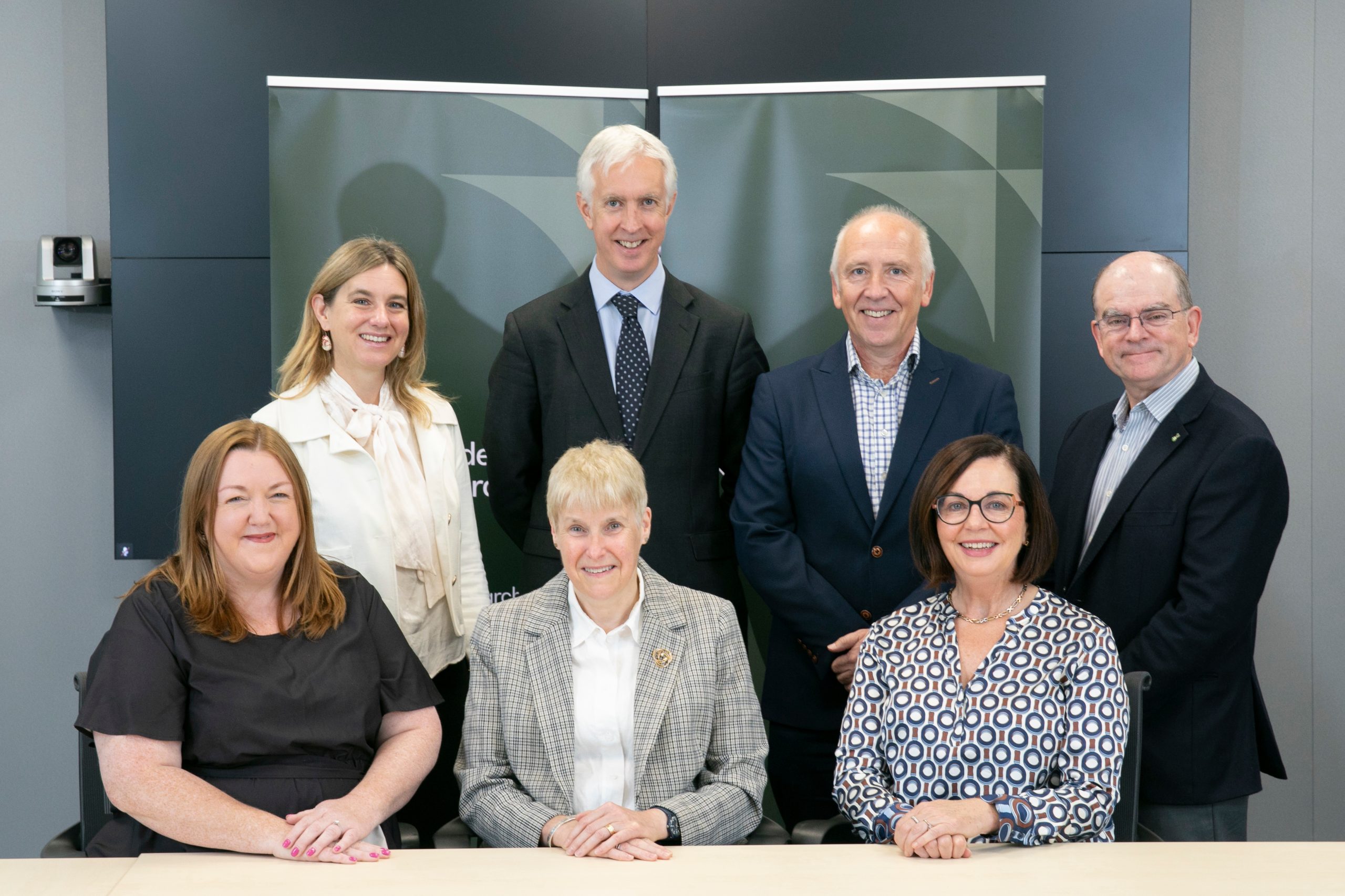 This image shows 7 members of the Research Ireland board in a group sitting and standing.||This image shows an office setting with desk chairs side by side facing a desk. A pen and paper lay on the desk in front of each chair.|This image shows chairs in front of a large desk in a meeting room.|7 members of the Research Ireland board in a group sitting and standing.|This image shows 7 members of the Research Ireland board in a group sitting and standing.