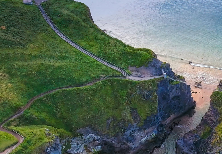 |The rope bridge connecting the two cliffs in Northern Ireland it is called the Carrick-a-Rede Rope Bridge taken in an aerial shot