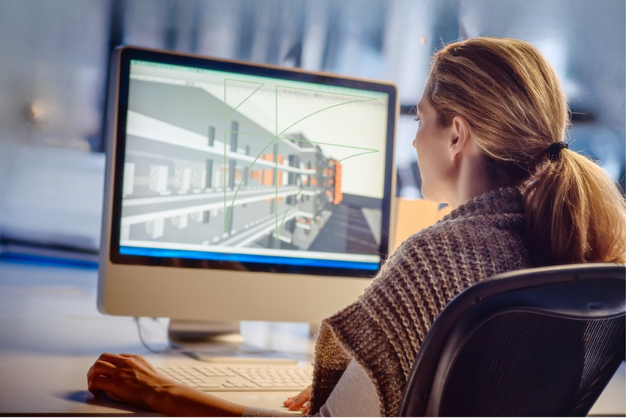Person sitting at a desk looking at a computer screen