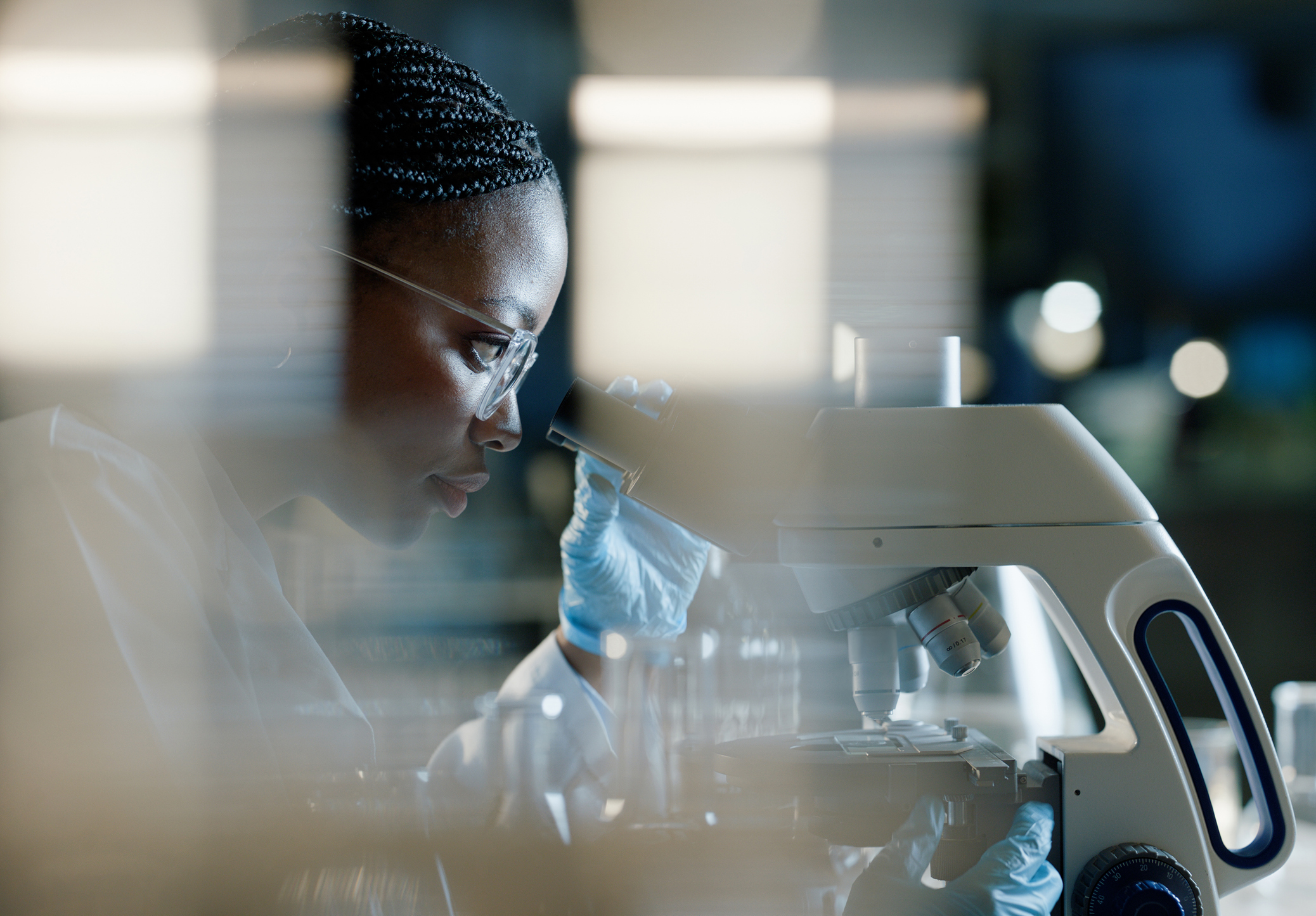 Female looking into a microscope.